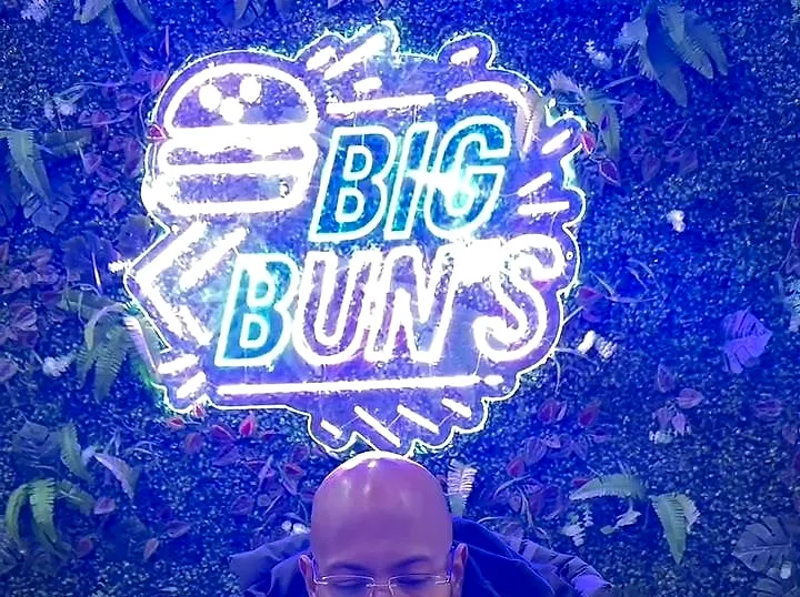 Le néon Big Bun’s allumé sur le mur végétal de la salle