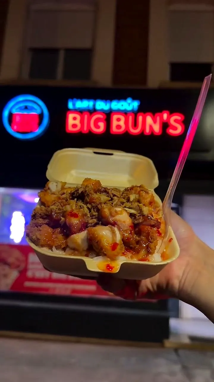 Un Tasty Crousty tenu devant l’enseigne Big Bun’s